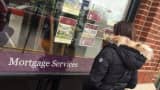 A woman looks at real estate listings outside a Berkshire Hathaway Home Services office in Montclair, N.J.